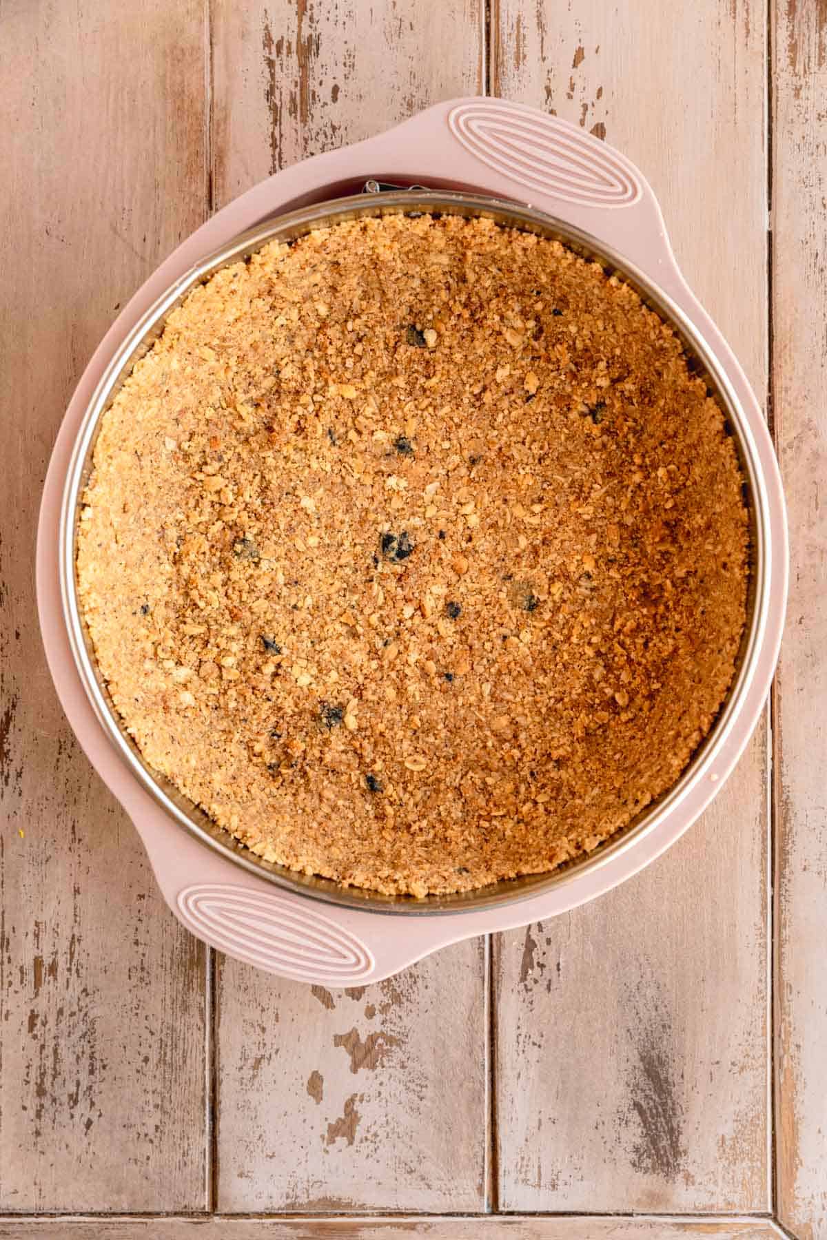 Lemon cookie crust in the bottom of a spring form pan.