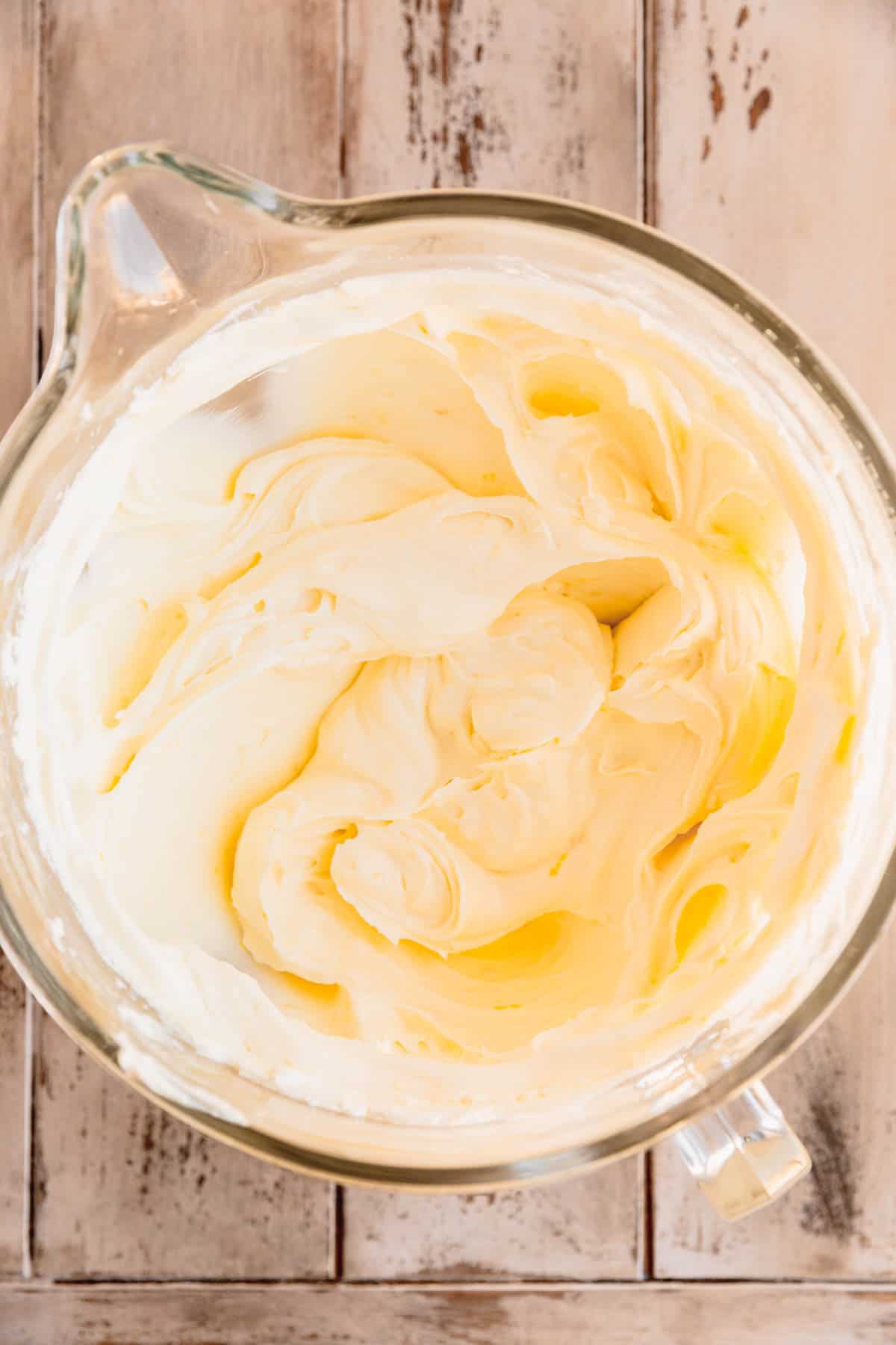 Cream cheese whipped in the bowl of a stand mixer. 