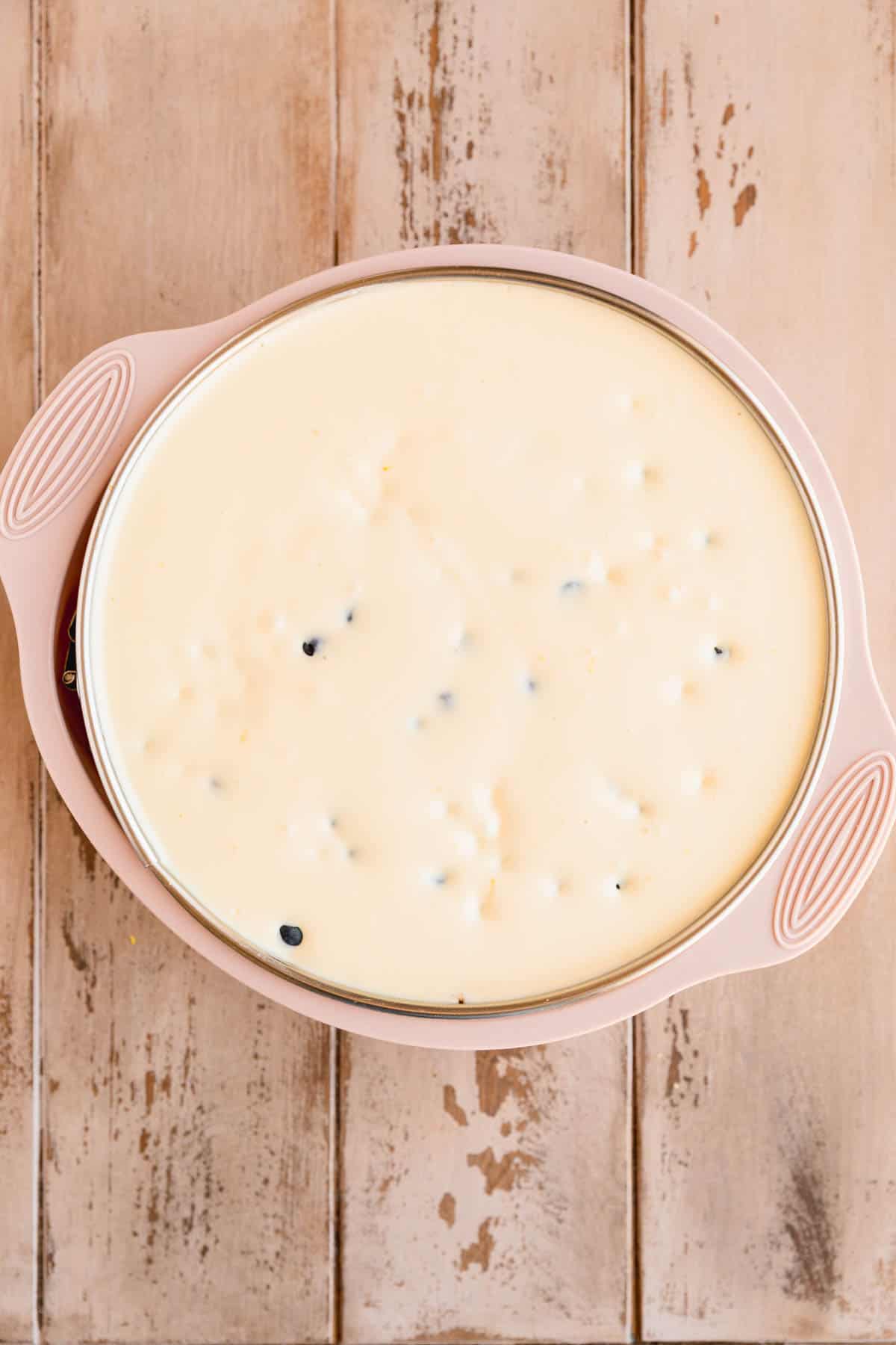 Lemon cheesecake batter poured over the crust in the spring form pan.