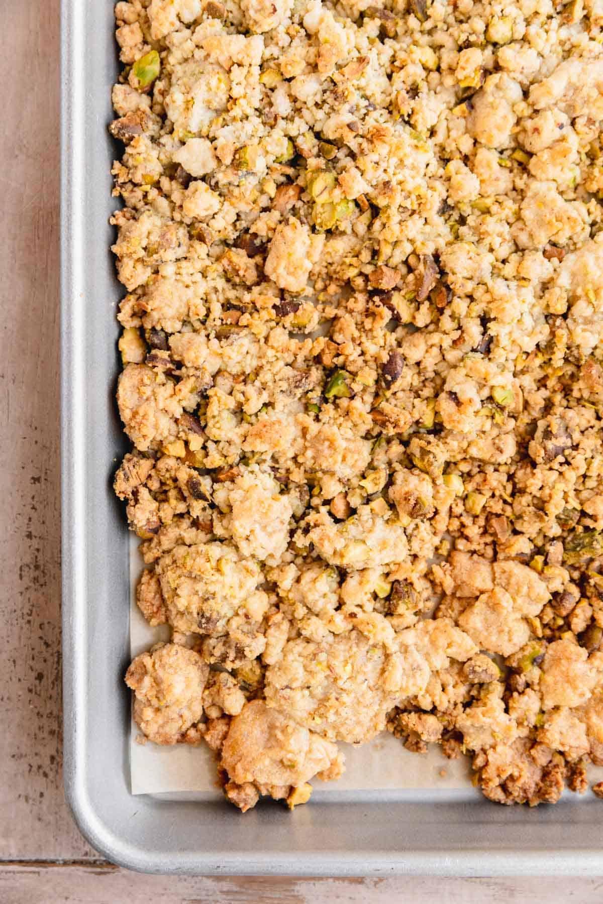 Pistachio crumble baked on a sheet tray.