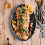 Mediterranean Citrus Roasted Salmon with Olive Relish on a serving platter with potatoes.