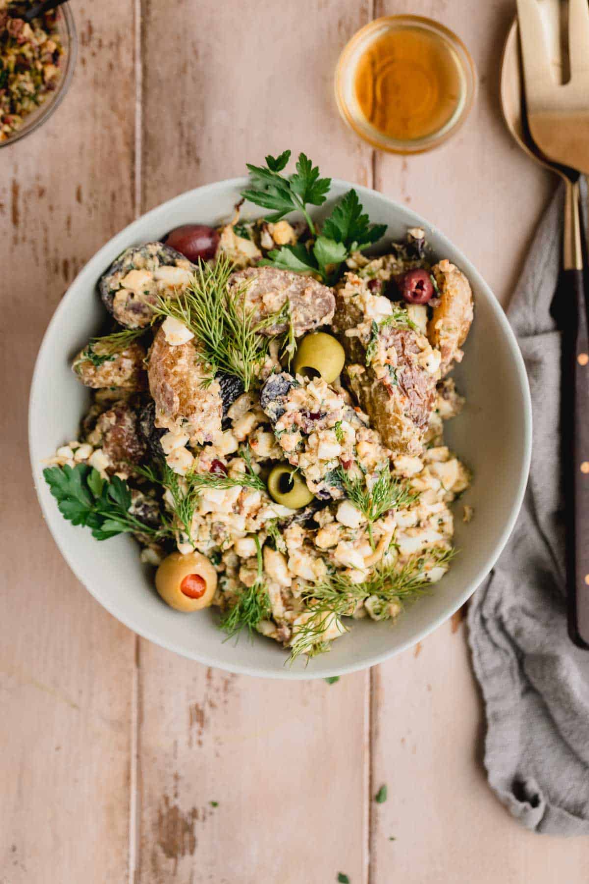 Mediterranean Fingerling Potato Salad with olive tapenade and herbs in a bowl. 