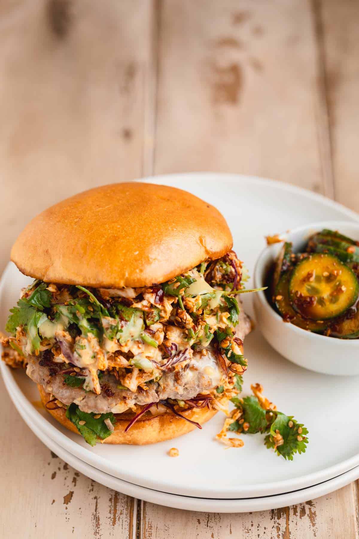 Pork Dumpling Burger on a plate with pickles.