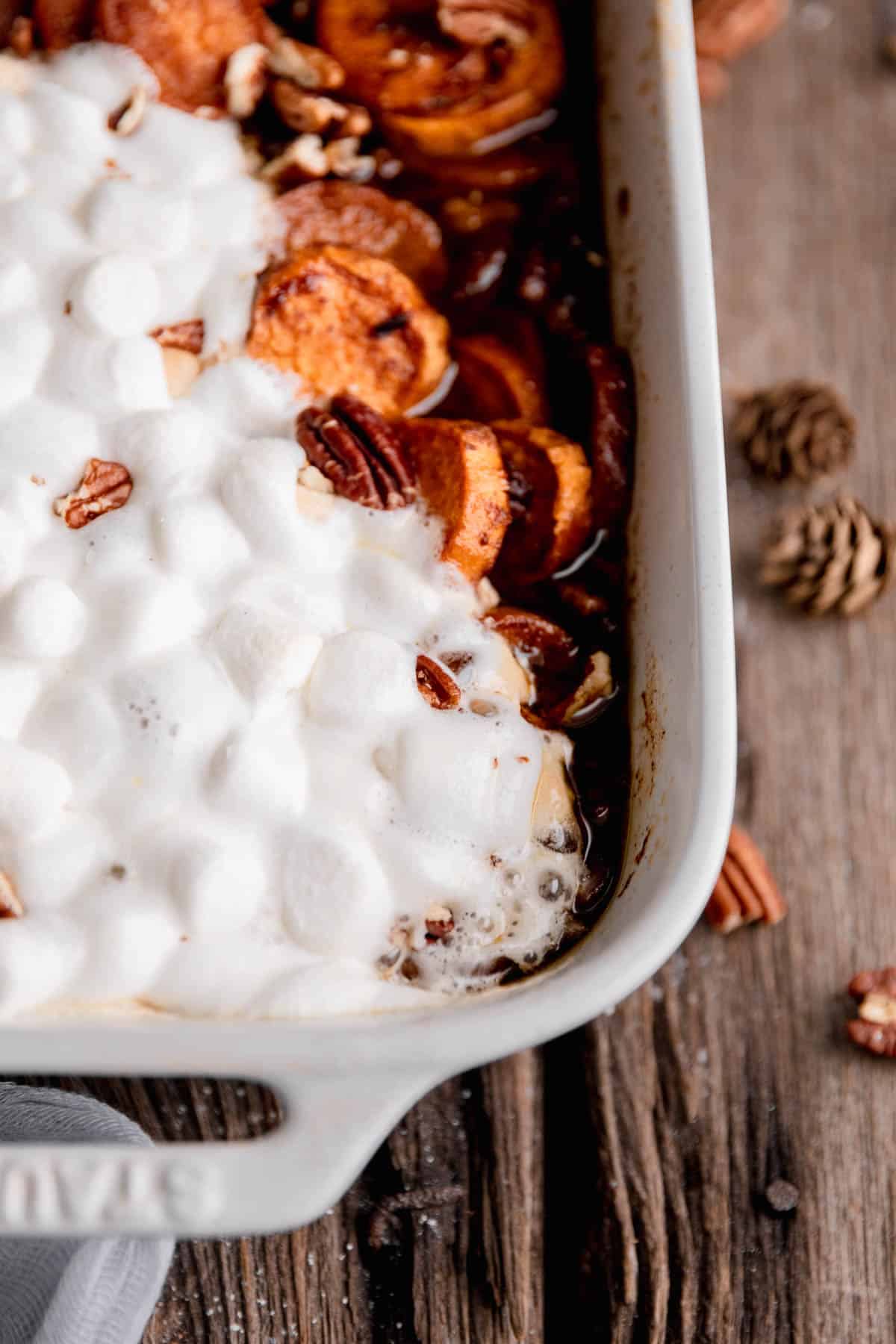 Candied sweet potatoes with marshmallows in a baking dish.