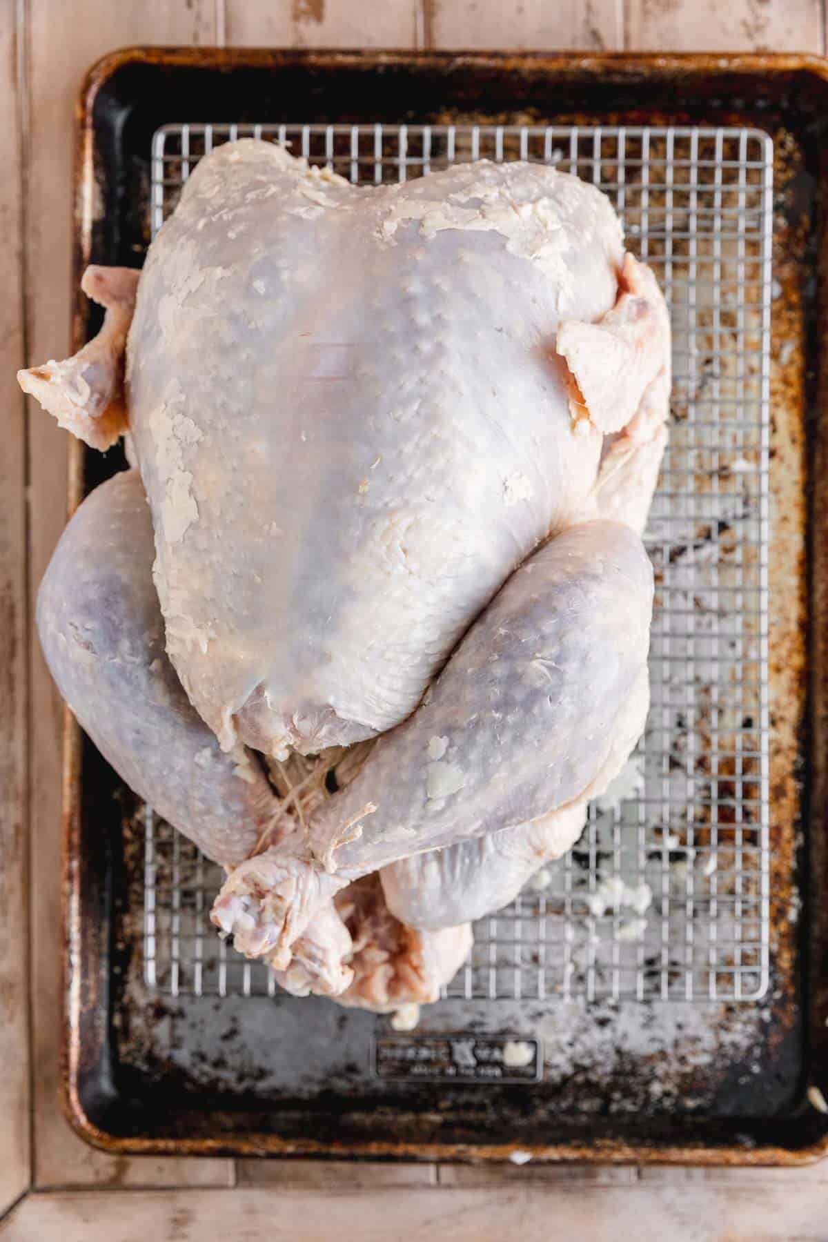 Turkey with salt sugar mixture and butter on a sheet tray.