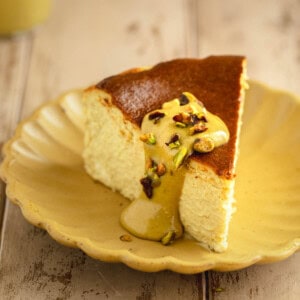 Pistachio Basque Cheesecake on a plate topped with pistachio cream.