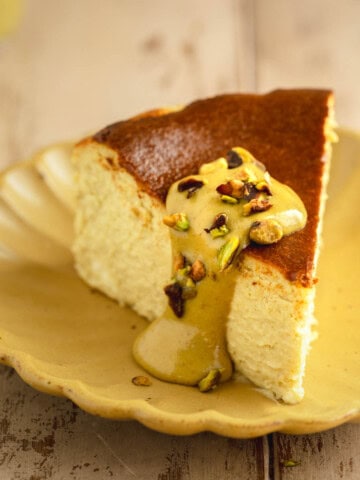 Pistachio Basque Cheesecake on a plate topped with pistachio cream.