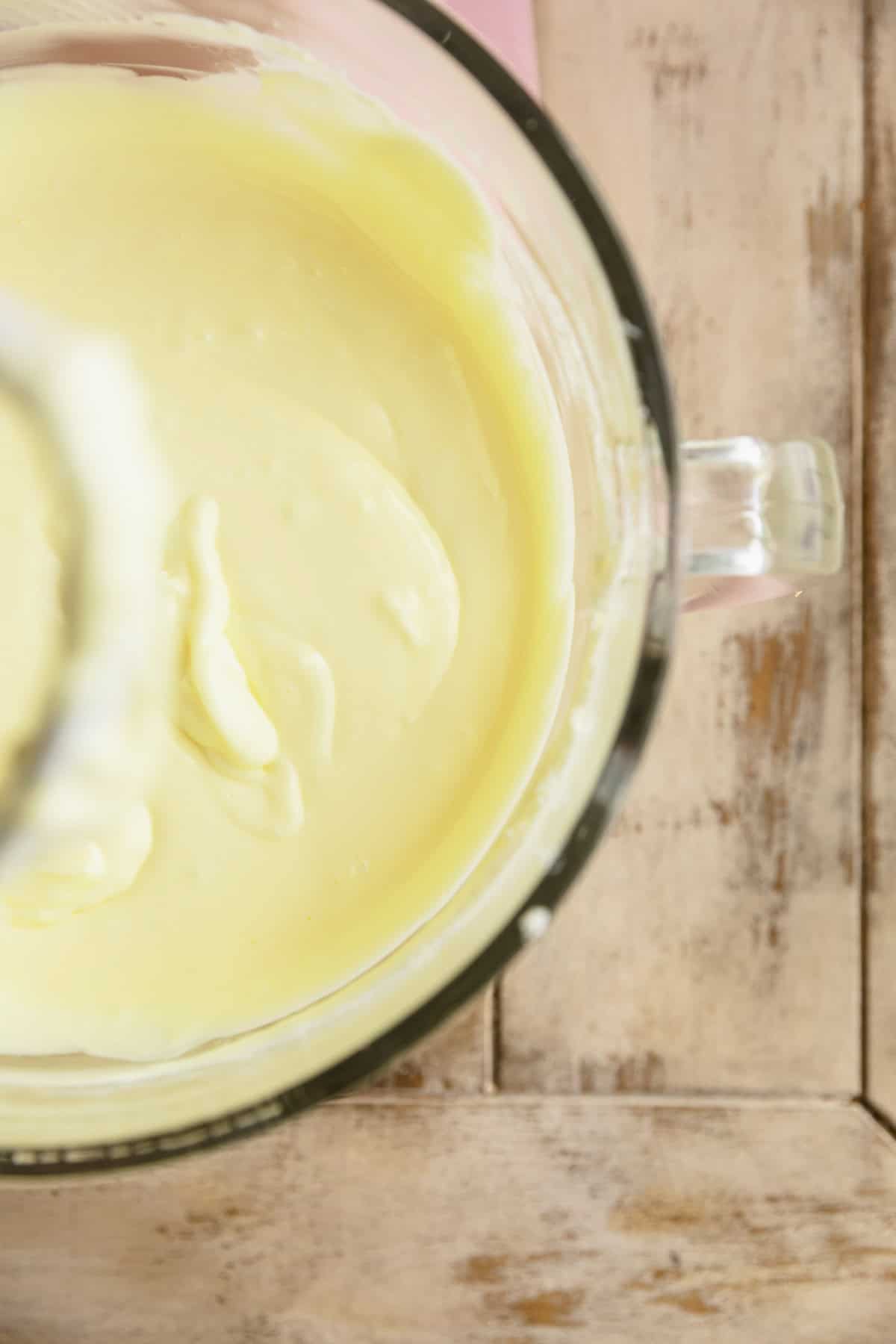 Pistachio cheesecake batter in bowl of a stand mixer.